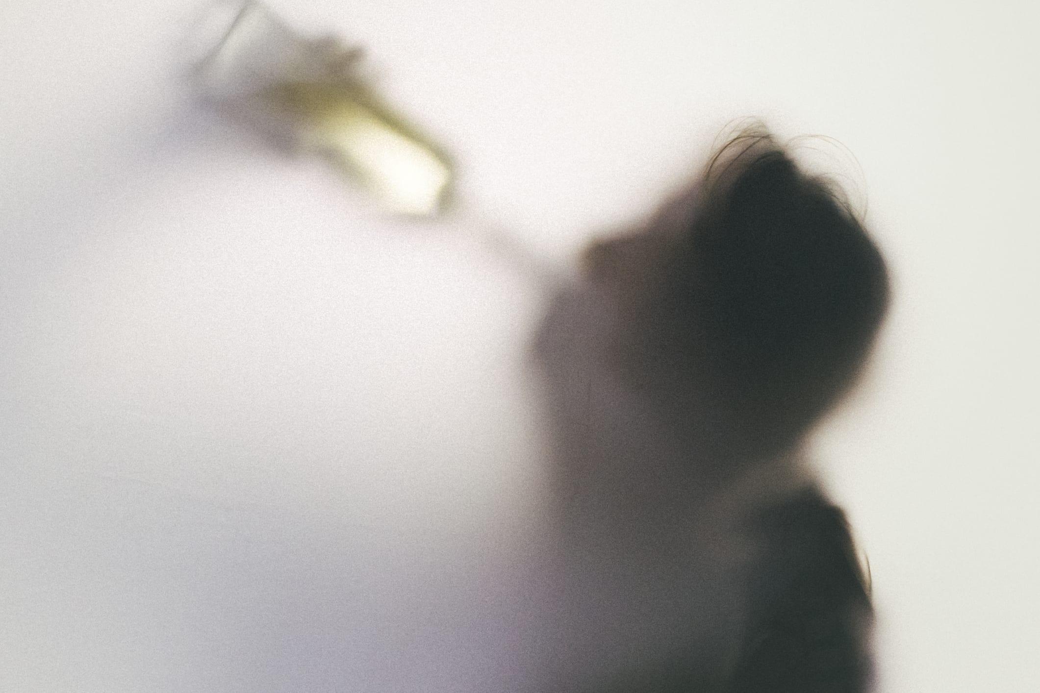 Senior woman drinking straight from the wine bottle.